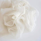 Close-up of warm white silk ribbon on a light gray background