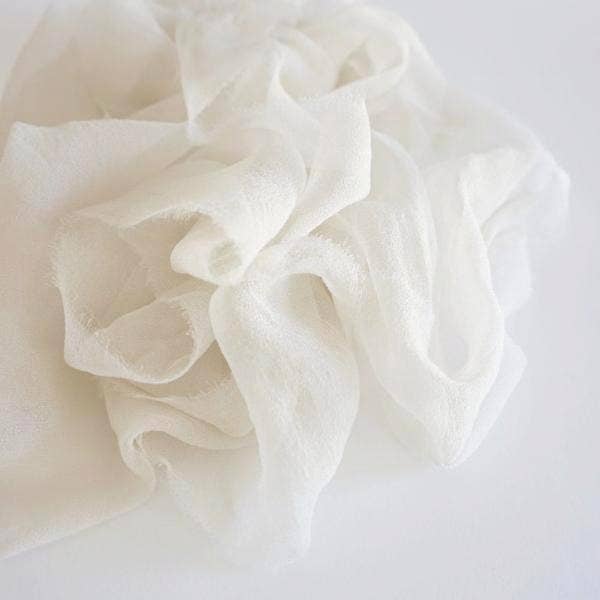 Close-up of warm white silk ribbon on a light gray background